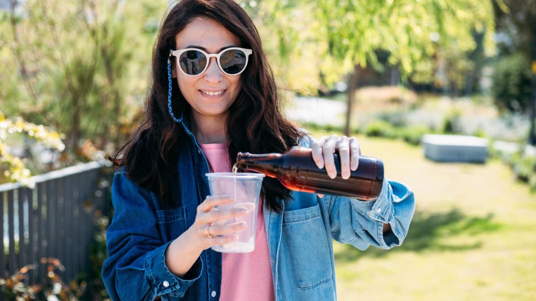Eine Mutter trinkt beim Kita-Fest ein Bier. 