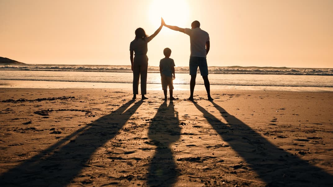 Familie am Strand im Sonnenuntergang.