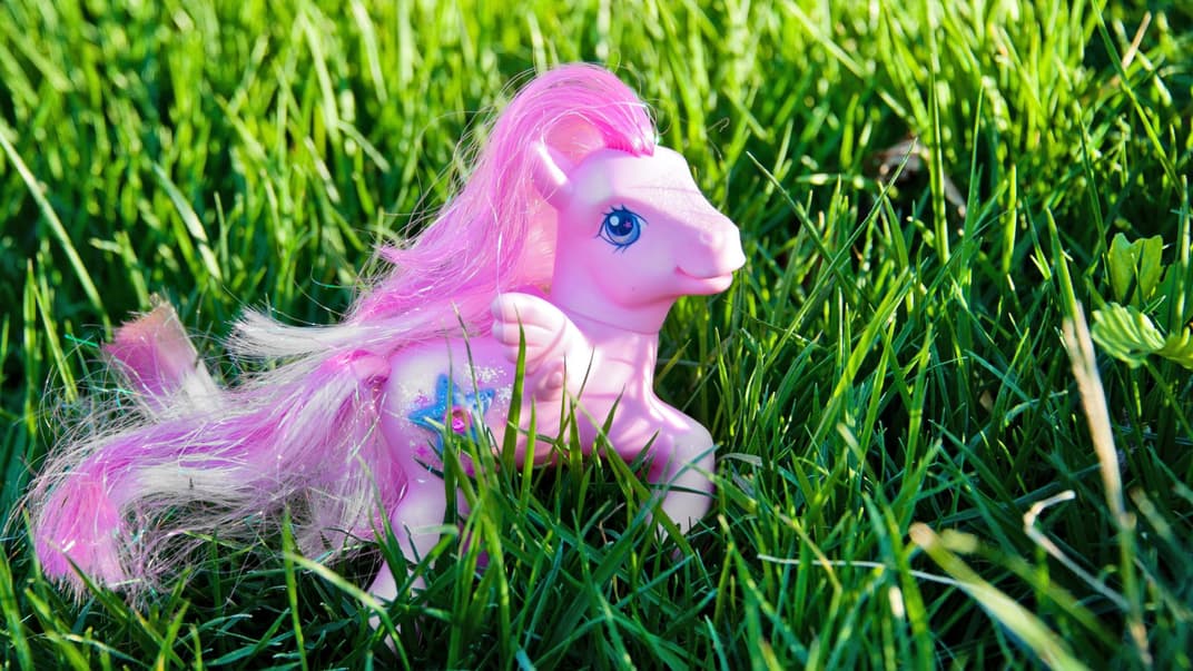 Ein pinkes Pferd, das zu den "My littly Pony" von früher gehört, steht auf dem Rasen.