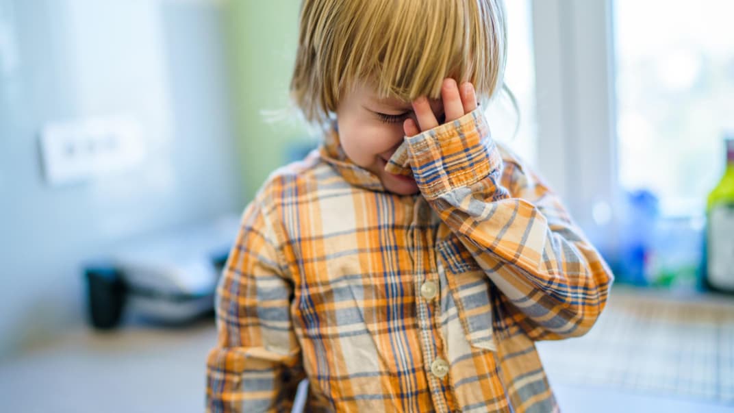 Kleiner Junge weint beim Abschied von Eltern. 