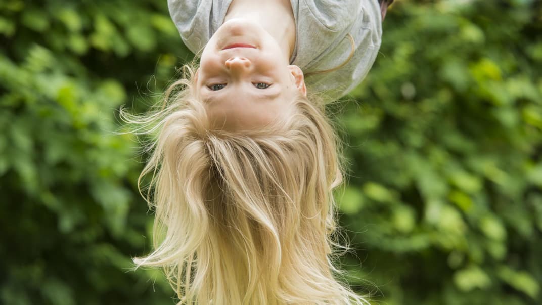 Fröhliches Mädchen hängt kopfüber.