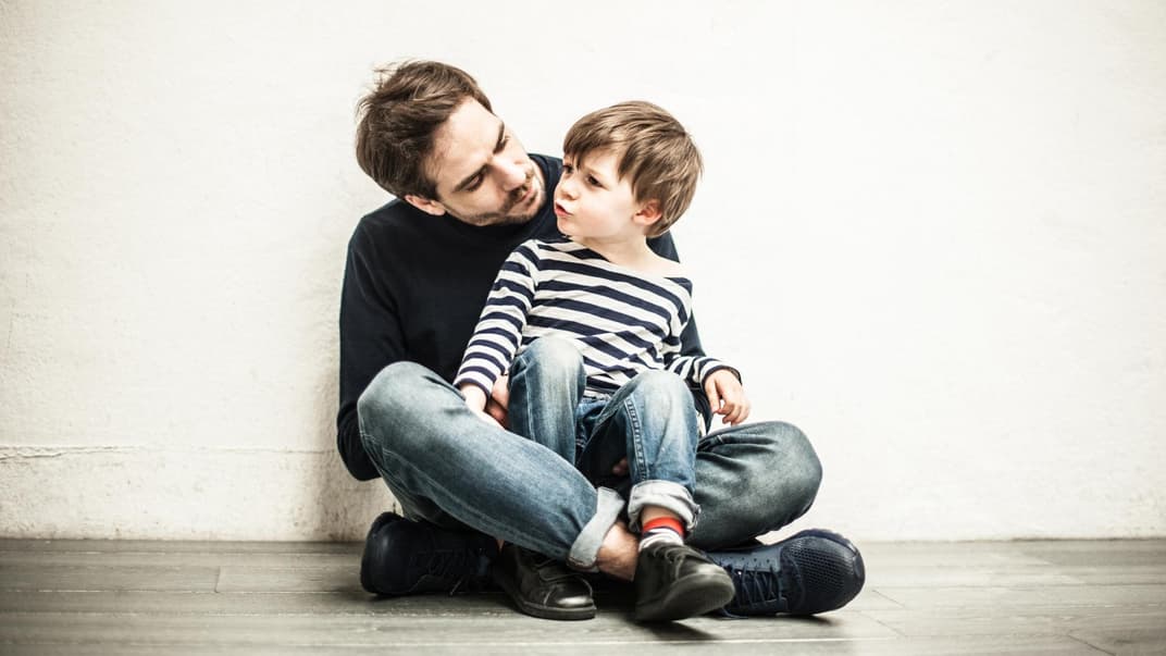 Sohn sitzt bei seinem Vater auf dem Schoß.