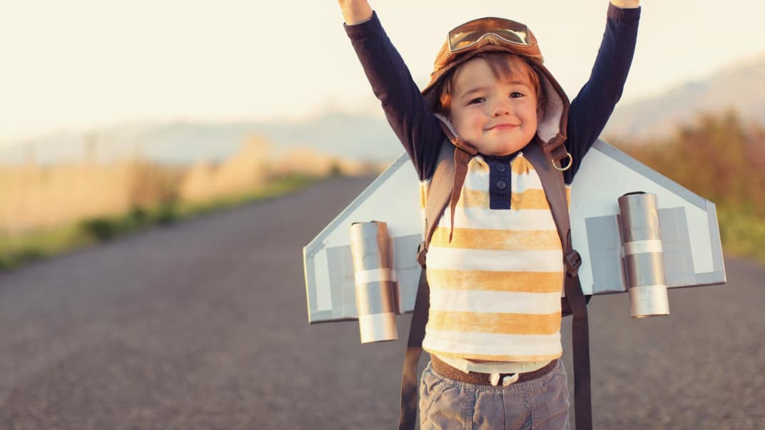 Junge mit Flügeln auf dem Rücken und erhobenen Armen.