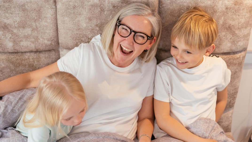 Oma lacht mit ihren beiden Enkeln.