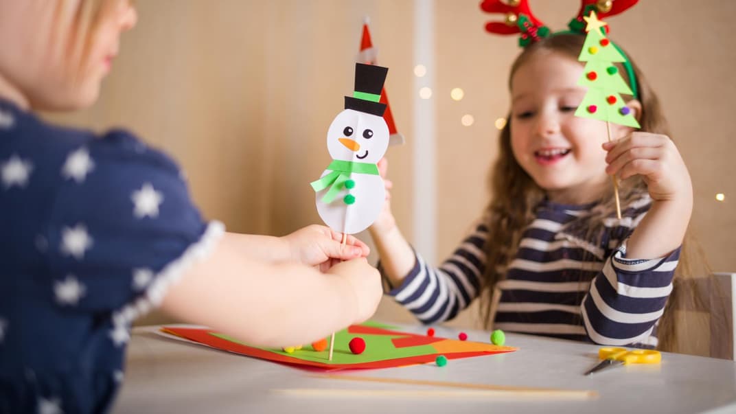 Zwei Kinder basteln Schneemänner