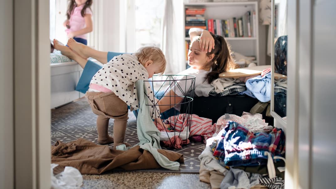 Gestresste Mutter mit zwei Kleinkindern zu Hause.