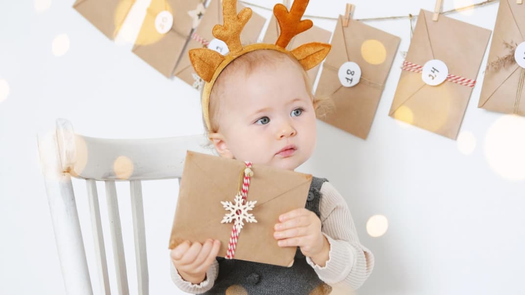 Baby will ein Türchen vom Adventskalender öffnen.