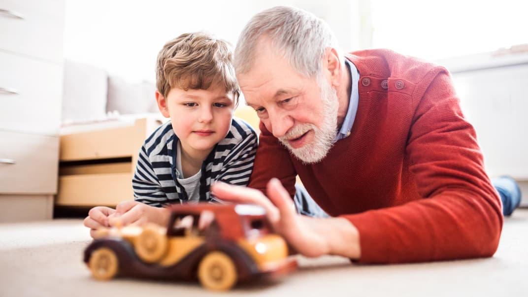 Großvater spielt mit seinem Enkel Auto.