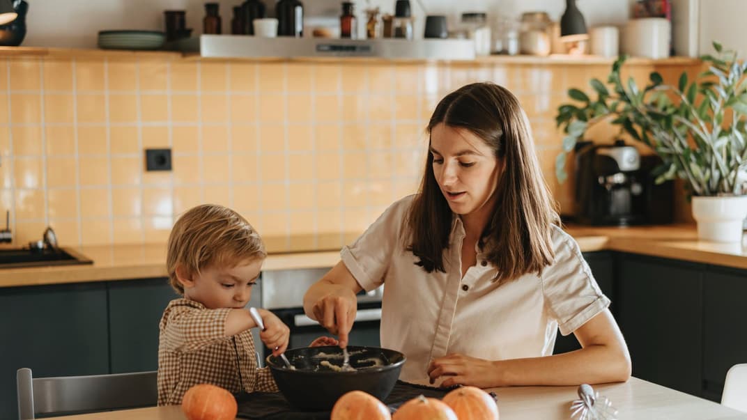 Eine Mama kocht mir ihrem Sohn nach Montessori. 