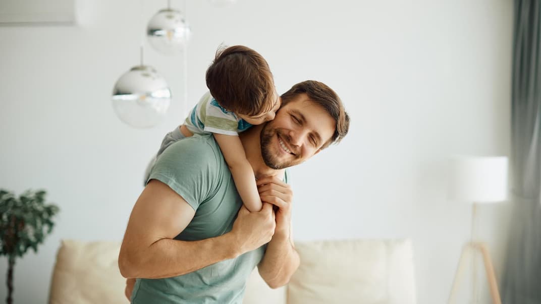 Vater trägt seinen Sohn auf dem Rücken.