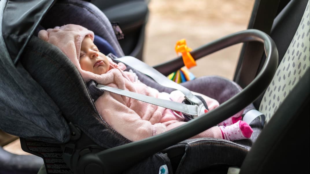 Ein Baby, das im Auto eingeschlafen ist. 