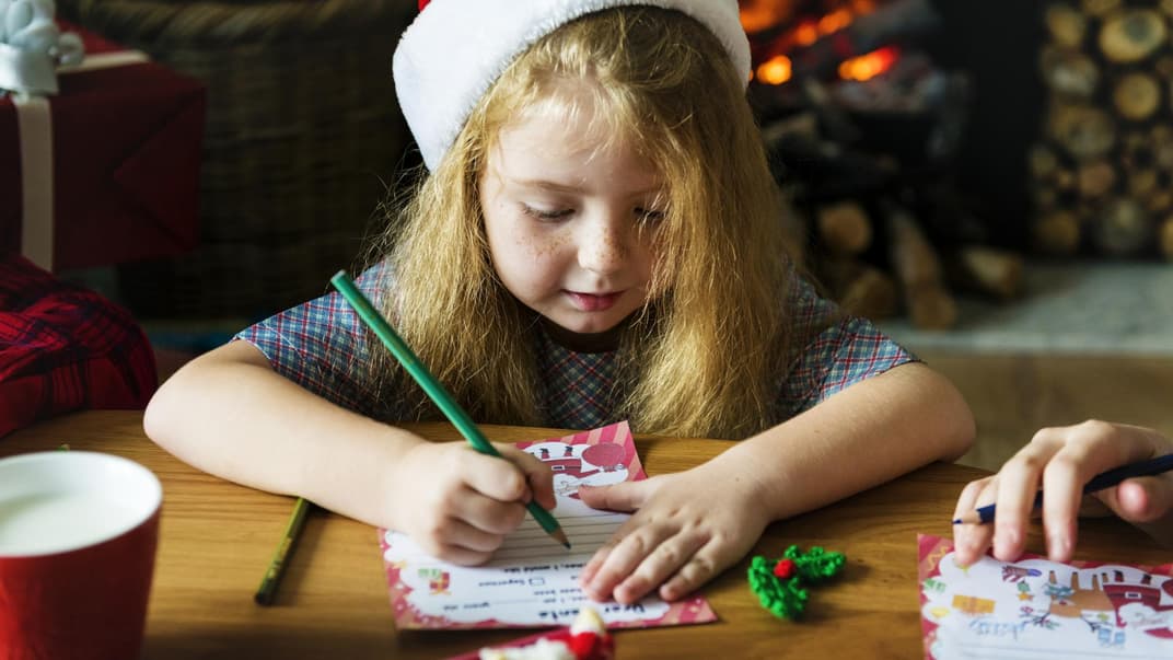 Kleines Mädchen schreibt einen Wunschzettel.