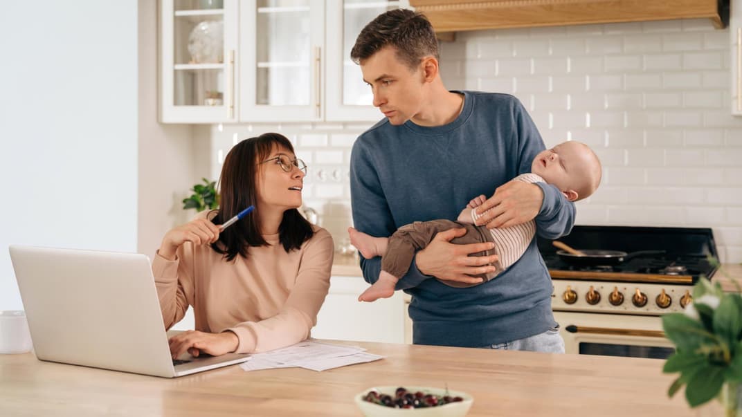 Junge Eltern mit Baby besprechen das Thema Finanzen.