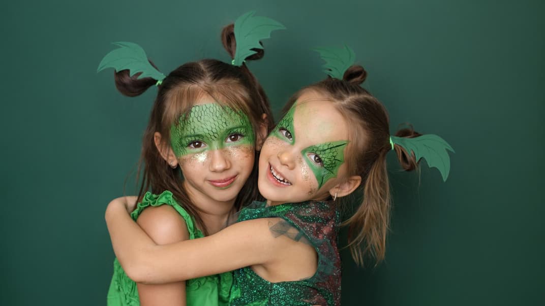 Mädchen, die als Drachen geschminkt sind.