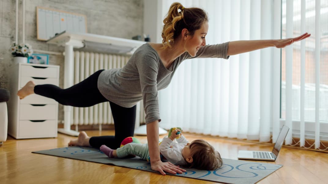 Eine Mama macht nach der Geburt Beckenbodentraining mit ihrem Baby. 