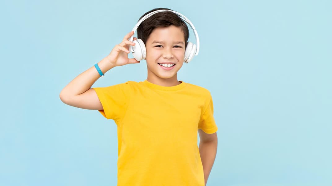 10-jähriger Junge hört Musik mit Headphones.