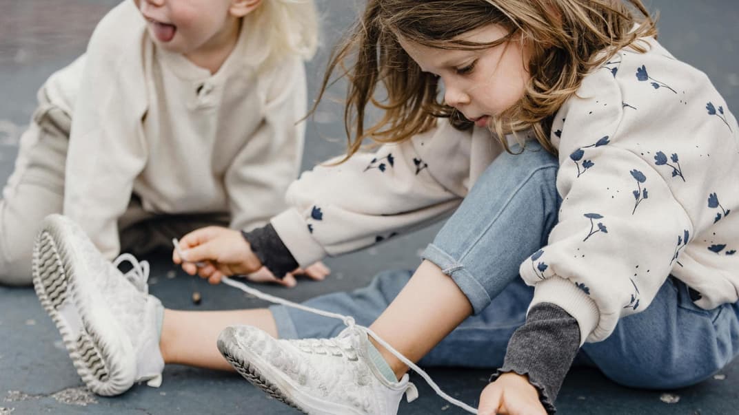 Mädchen bindet sich eine Schleife.