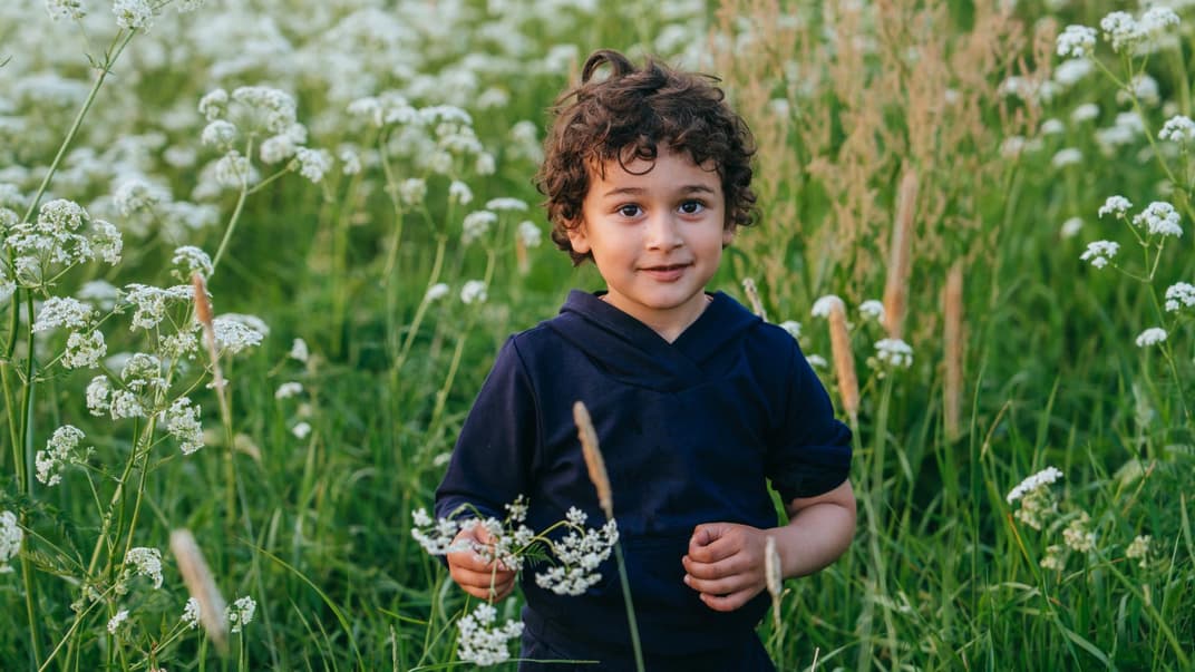 Ein kleiner Junge in einem Blumenfeld