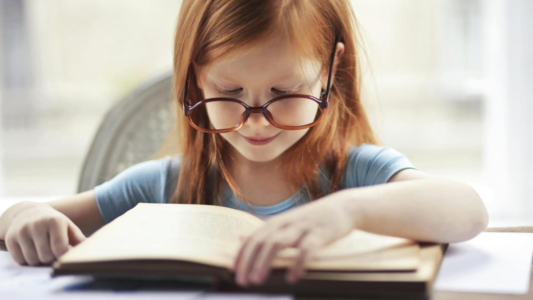 Kleines Mädchen liest ein Buch.
