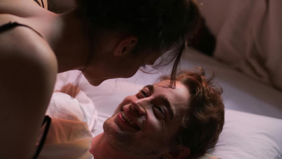 Fröhliches Pärchen im Bett.