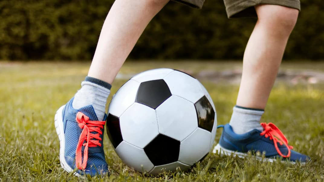 Jungsbeine mit Fußball.