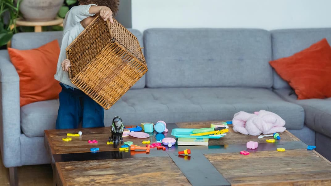 Kind schüttet eine Spielzeugkiste aus.
