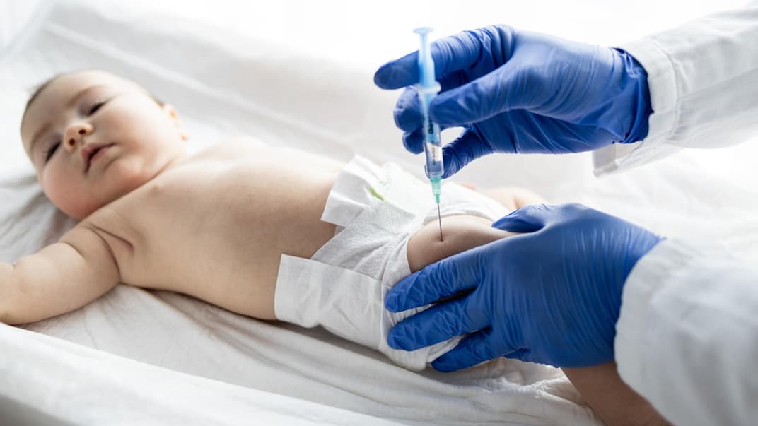 Ein Baby wird in den Oberschenkel geimpft.