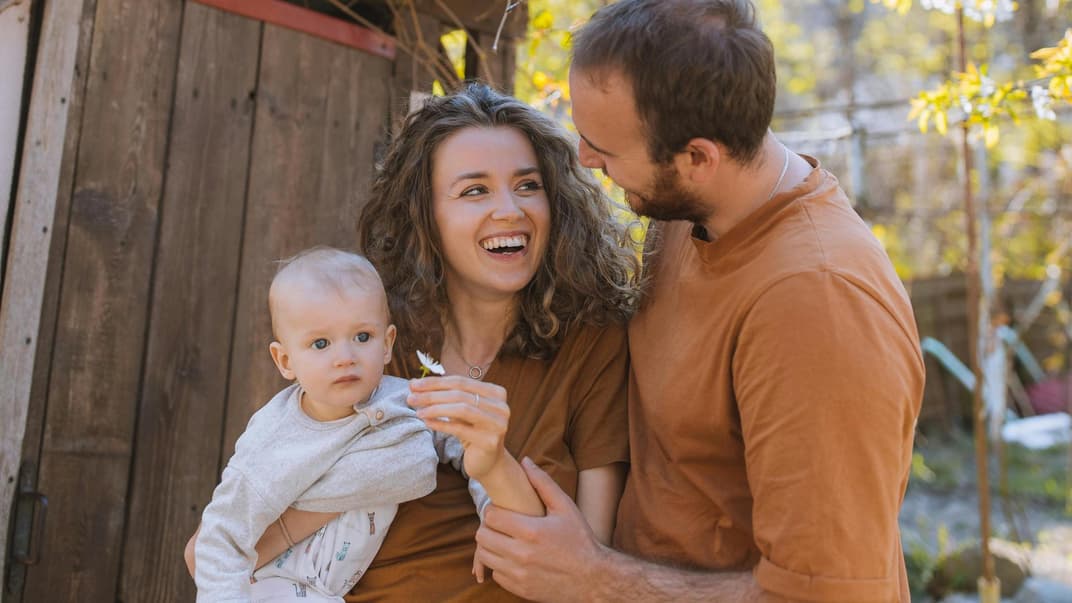 Glückliche Familie draußen mit Baby.