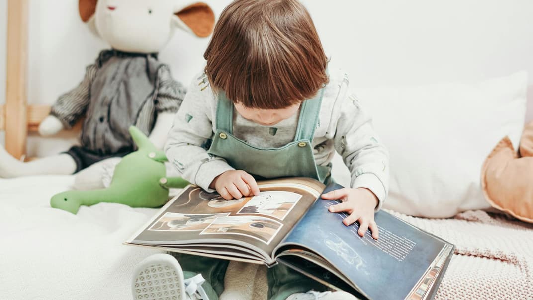 Ein Kleinkind liest ein Buch.