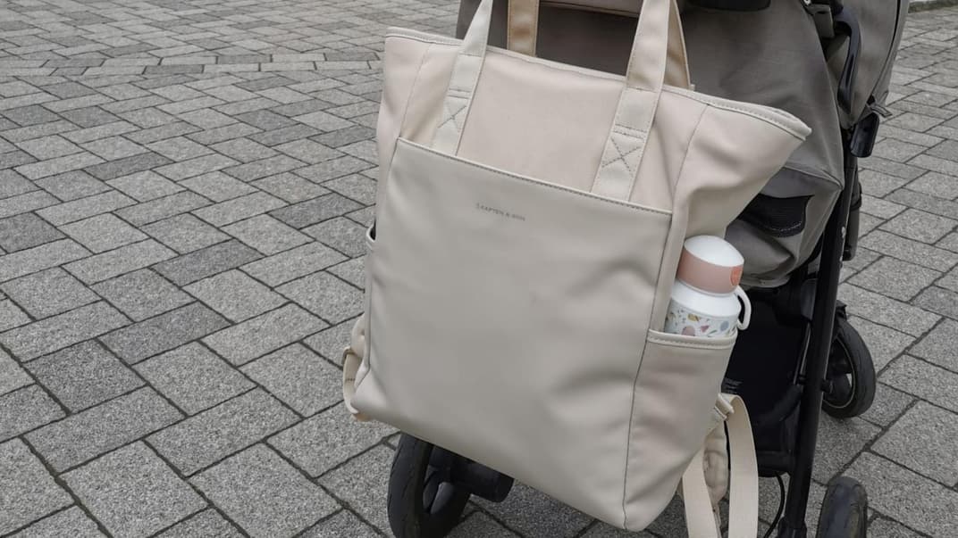Der Wickelrucksack in Sandstone von Kapten & Son hängt am Buggy unserer Redakteurin.