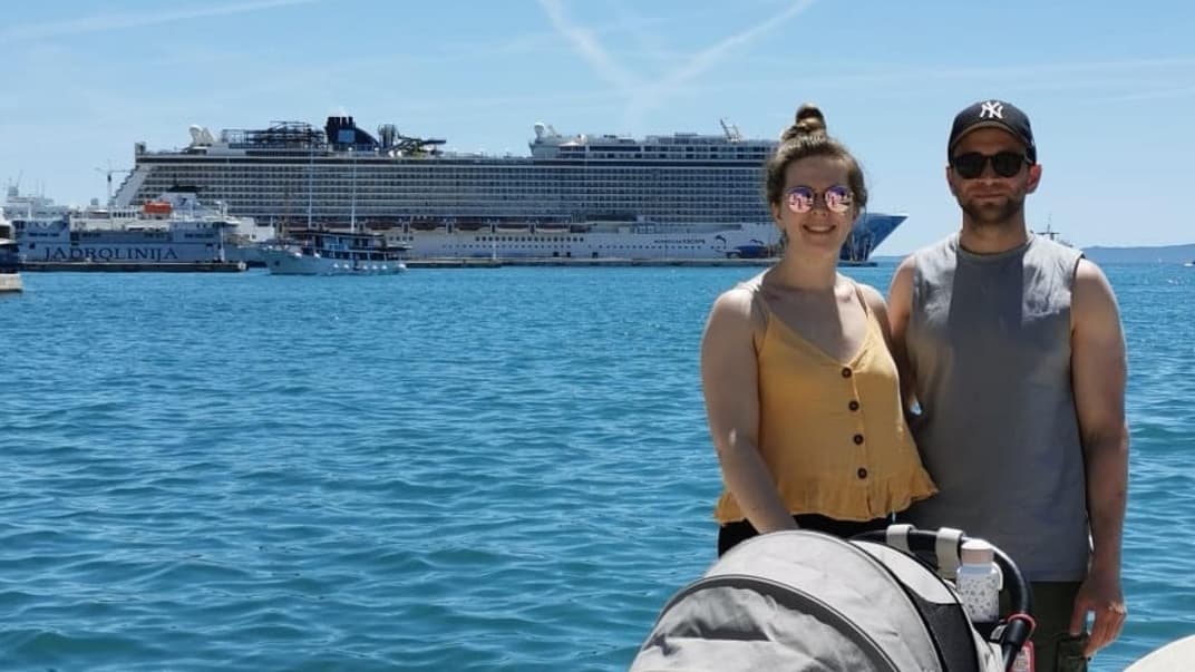 Unsere Autorin, ihr Mann und ihr Kind im Buggy stehen am Hafen in Split vor dem Kreuzfahrtschiff Norwegian Escape.