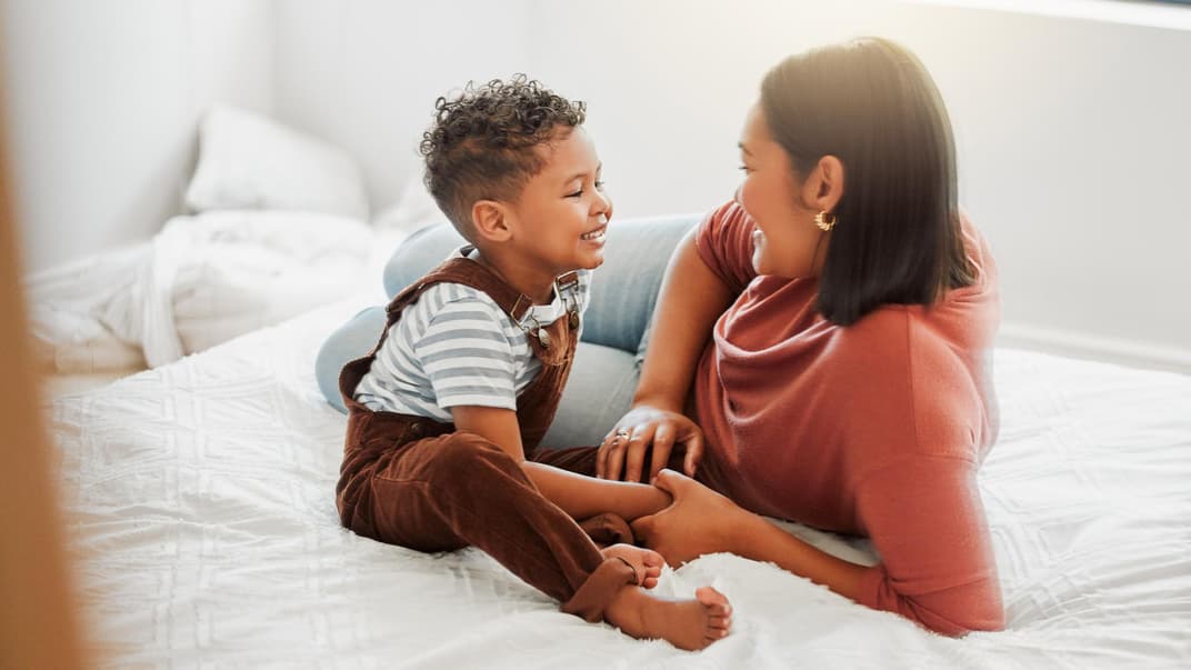 Mutter und Sohn liegen auf dem Bett und unterhalten sich.