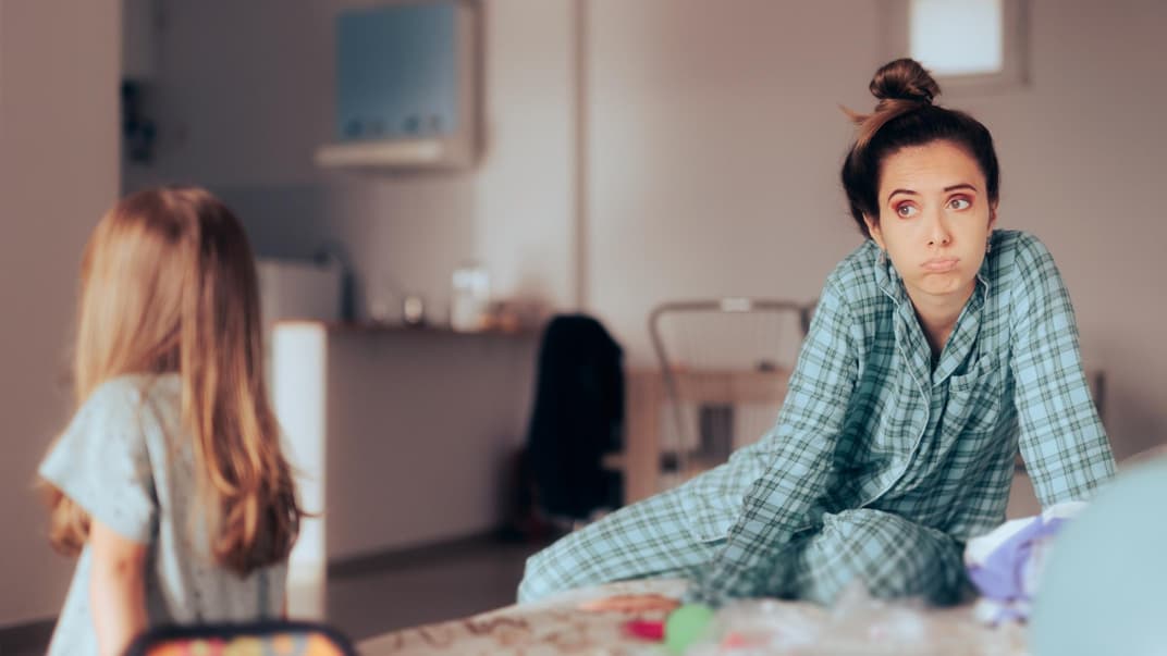 Erschöpfte Mutter mit ihrer Tochter zu Hause.