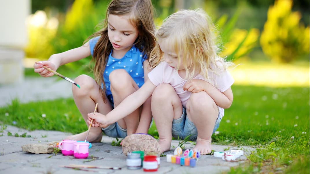 Kleine Mädchen basteln mit Steinen 