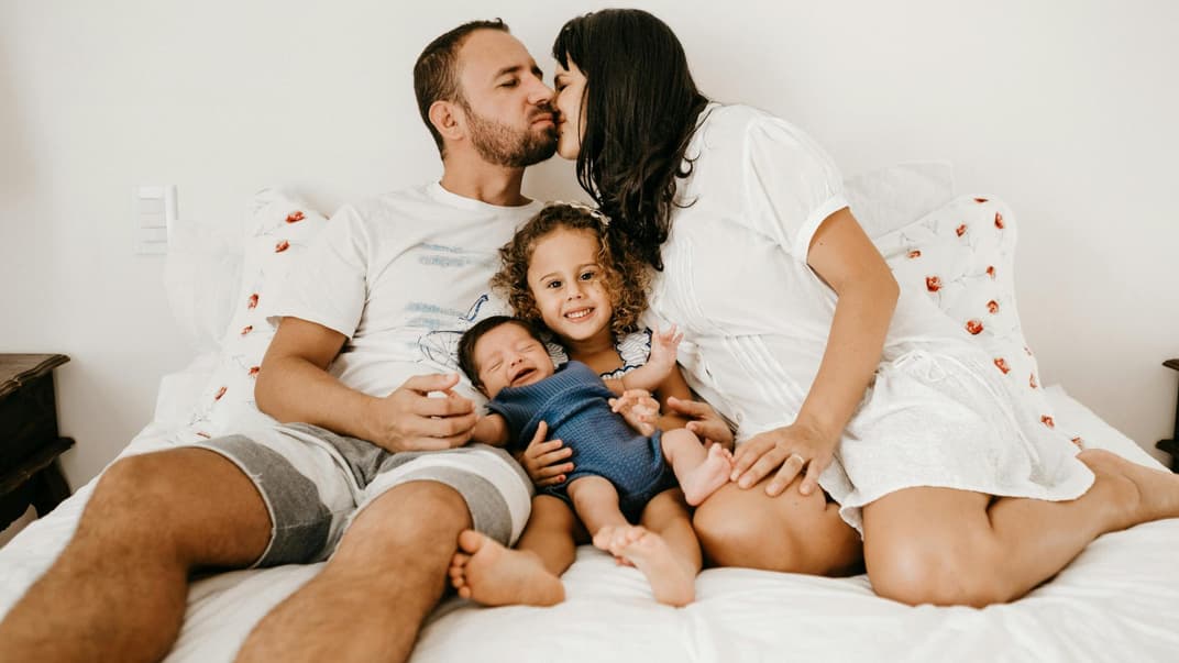 Vierköpfige Familie zusammen im Bett.