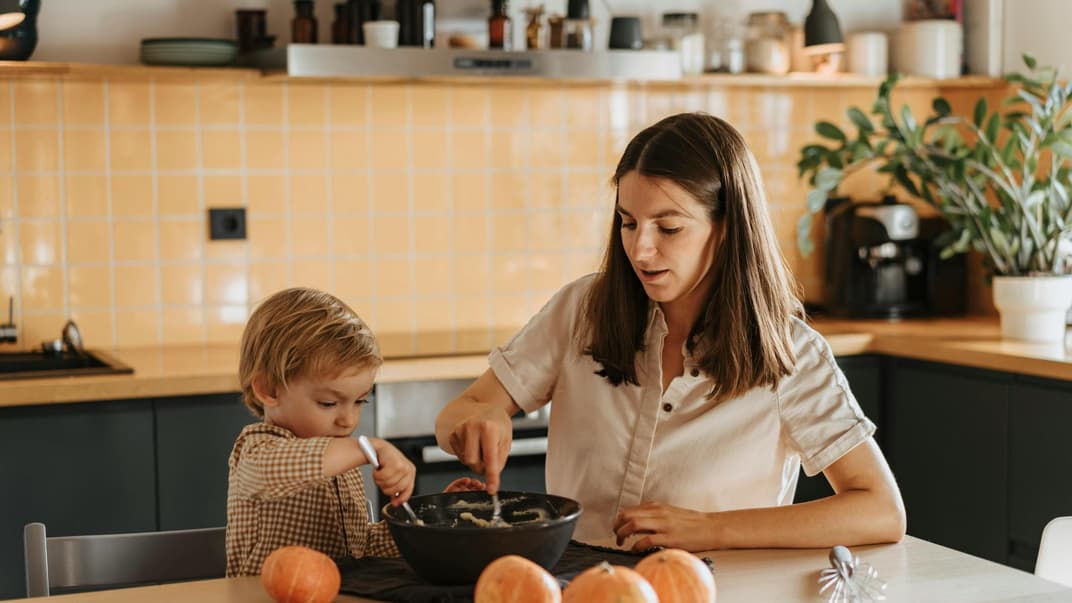 Eine Mutter kocht zusammen mit ihrem kleinen Sohn.