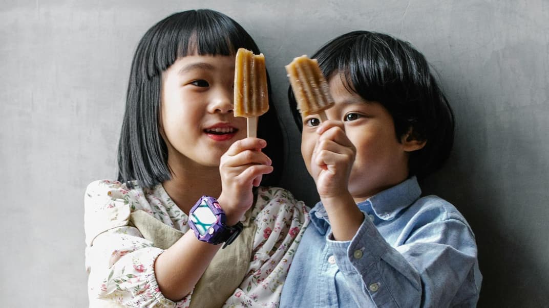 Zwei Kinder mit Fruchteis in der Hand.