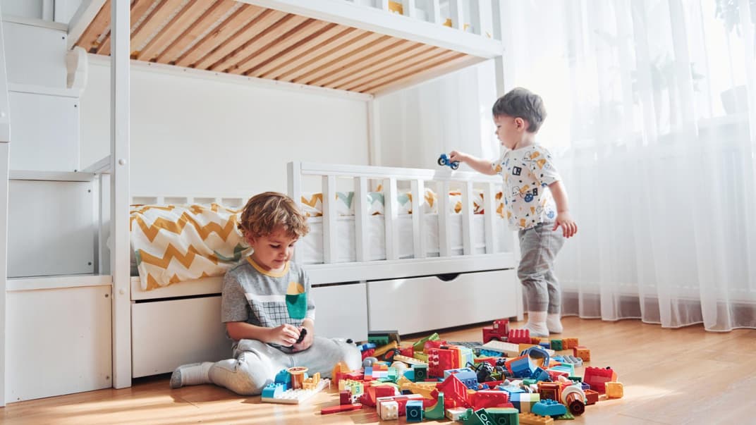 Zwei Jungs spielen neben ihrem Hochbett.