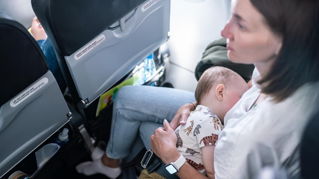 Mutter mit Baby im Flugzeug.