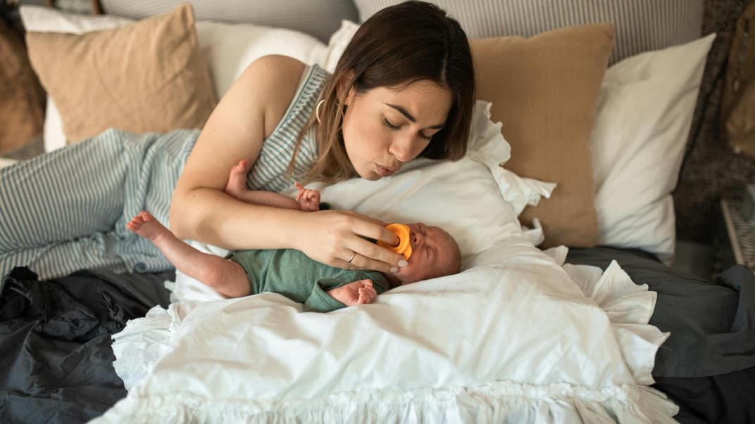 Eine Mutter tröstet ihr weinendes Baby.