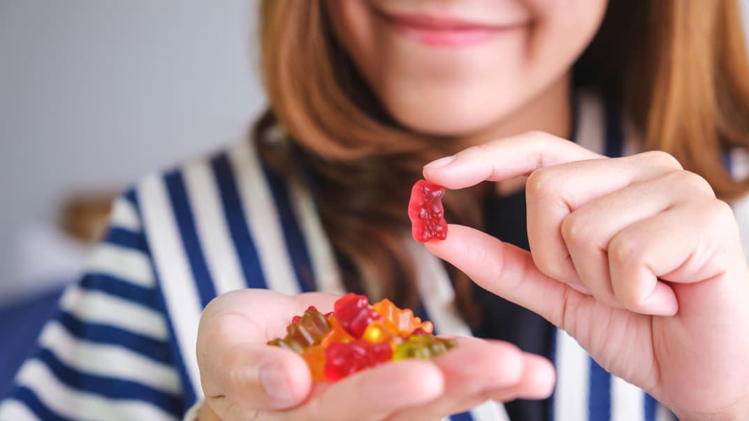 Eine Frau hält Gummibärchen in der Hand