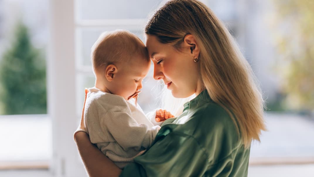 Mutter hält ihr Baby liebevoll auf dem Arm.