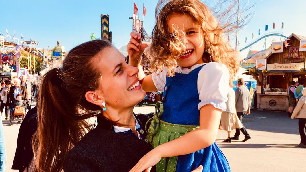 Eine Frau im Dirndl auf dem Oktoberfest mit ihrer Tochter. 