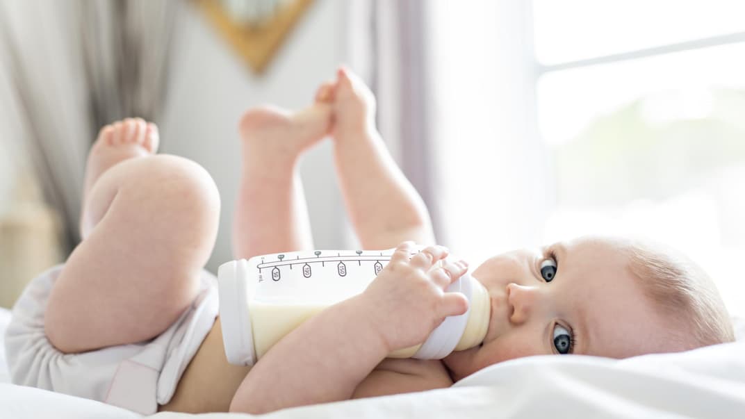 Baby trinkt aus Fläschchen.