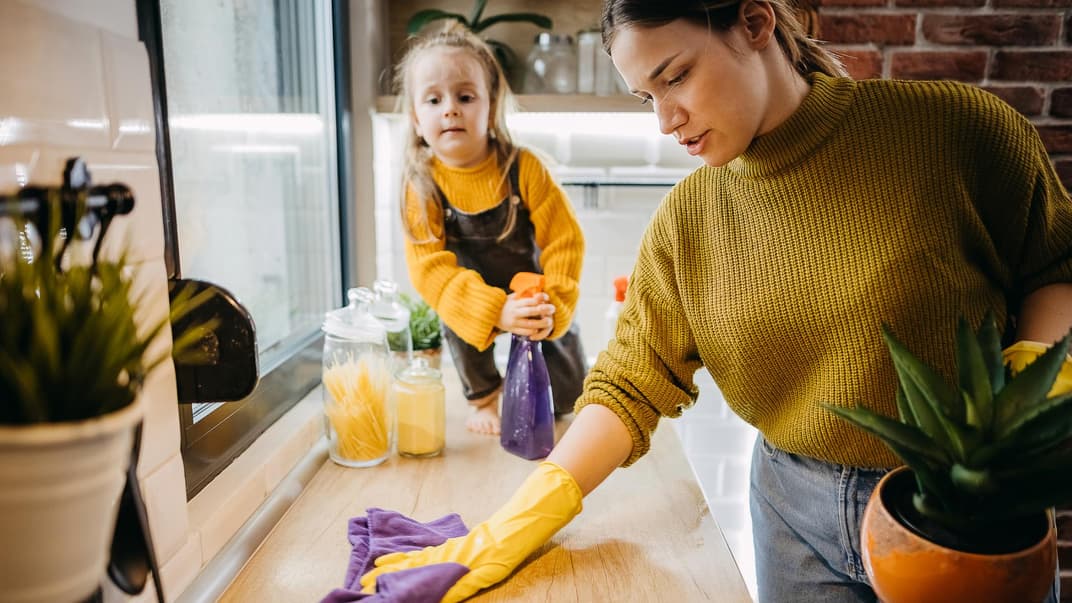 Mutter putzt die Küche mit ihrer Tochter.
