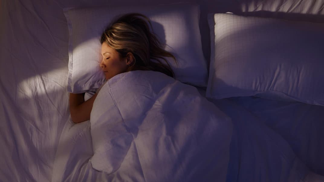 Eine Frau, die allein im Doppelbett schläft