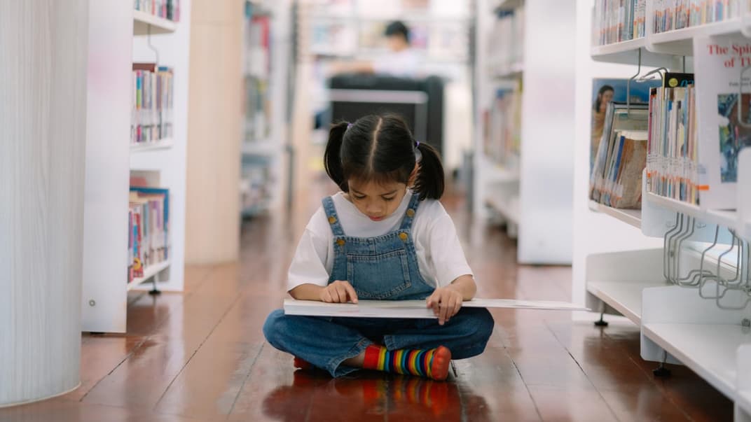 Mädchen liest in Kinderbuchhandlung.