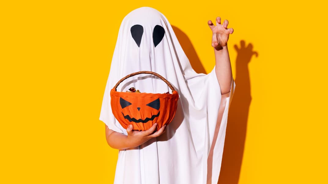 Kind zu Halloween als Gespenst verkleidet.