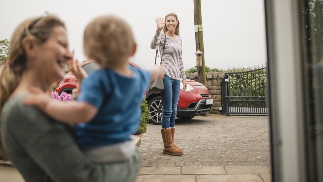 Nanny winkt mit Kleinkind der Mutter.