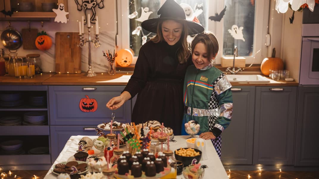 Mutter und Kind betrachten ihr Halloween-Buffet.